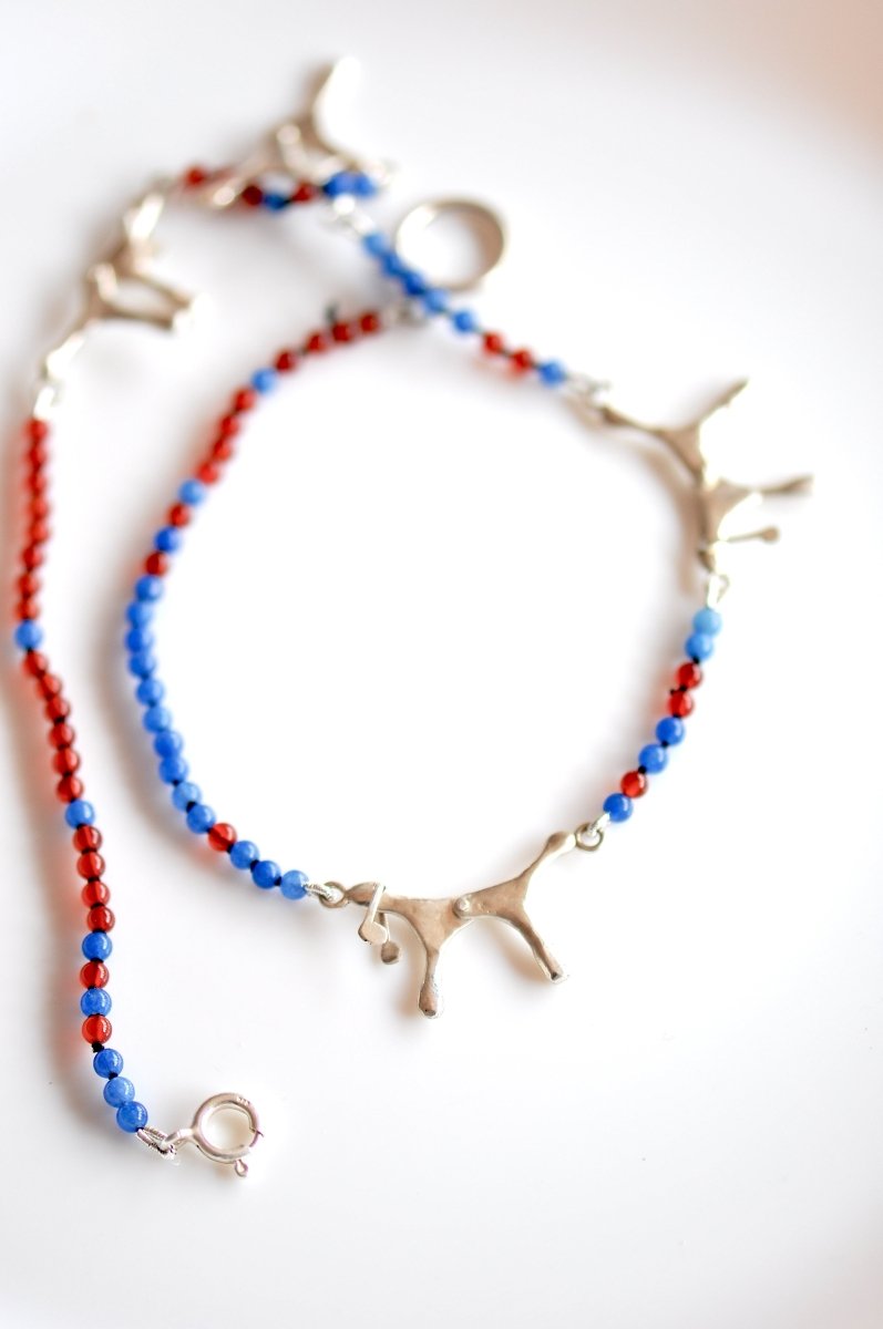 Handmade red and blue agate bead necklace with four articulated sterling silver dog charms, made in Barcelona