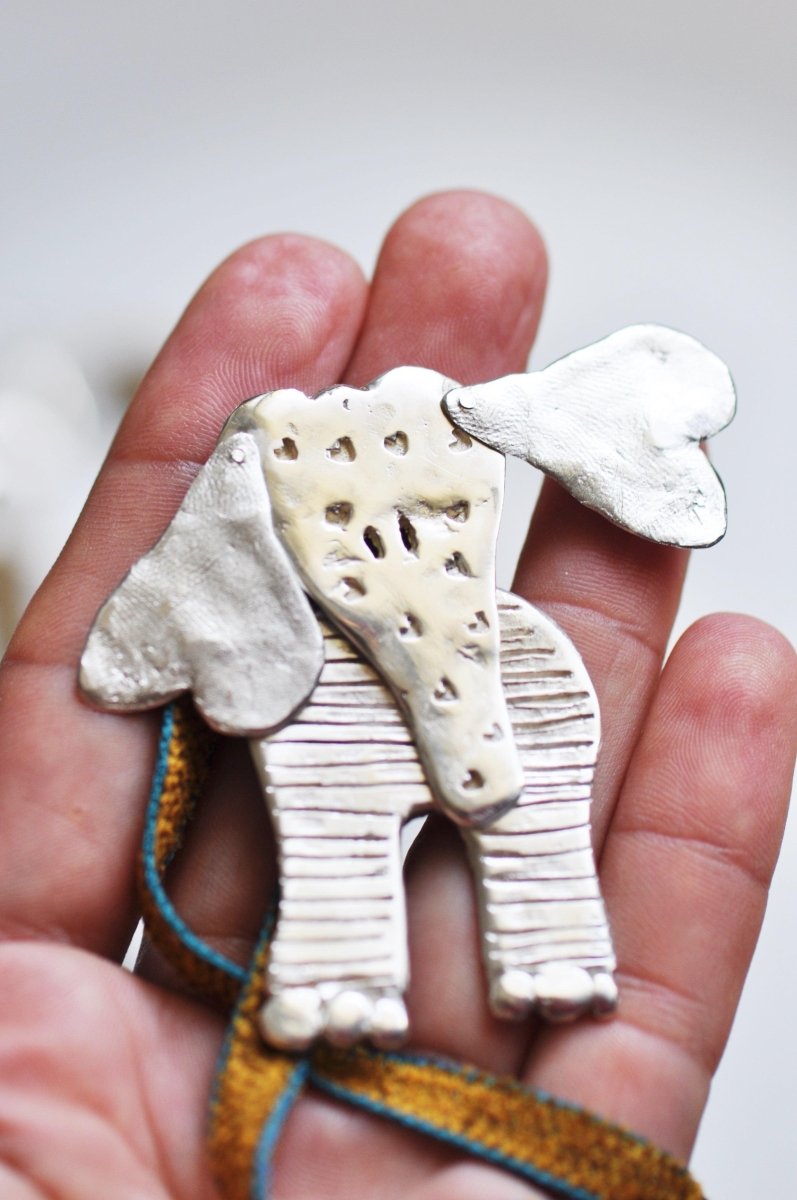 Handmade sterling silver articulated elephant necklace with textured sculptural design, whimsical animal jewelry