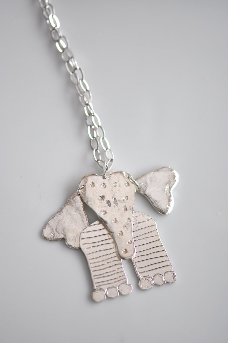 Handmade sterling silver articulated elephant necklace with textured sculptural design, whimsical animal jewelry
