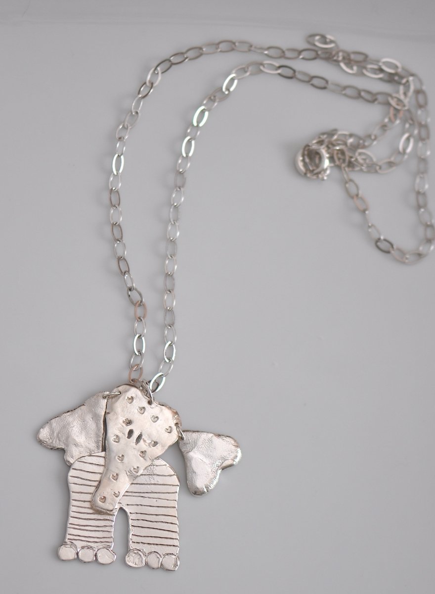 Handmade sterling silver articulated elephant necklace with textured sculptural design, whimsical animal jewelry