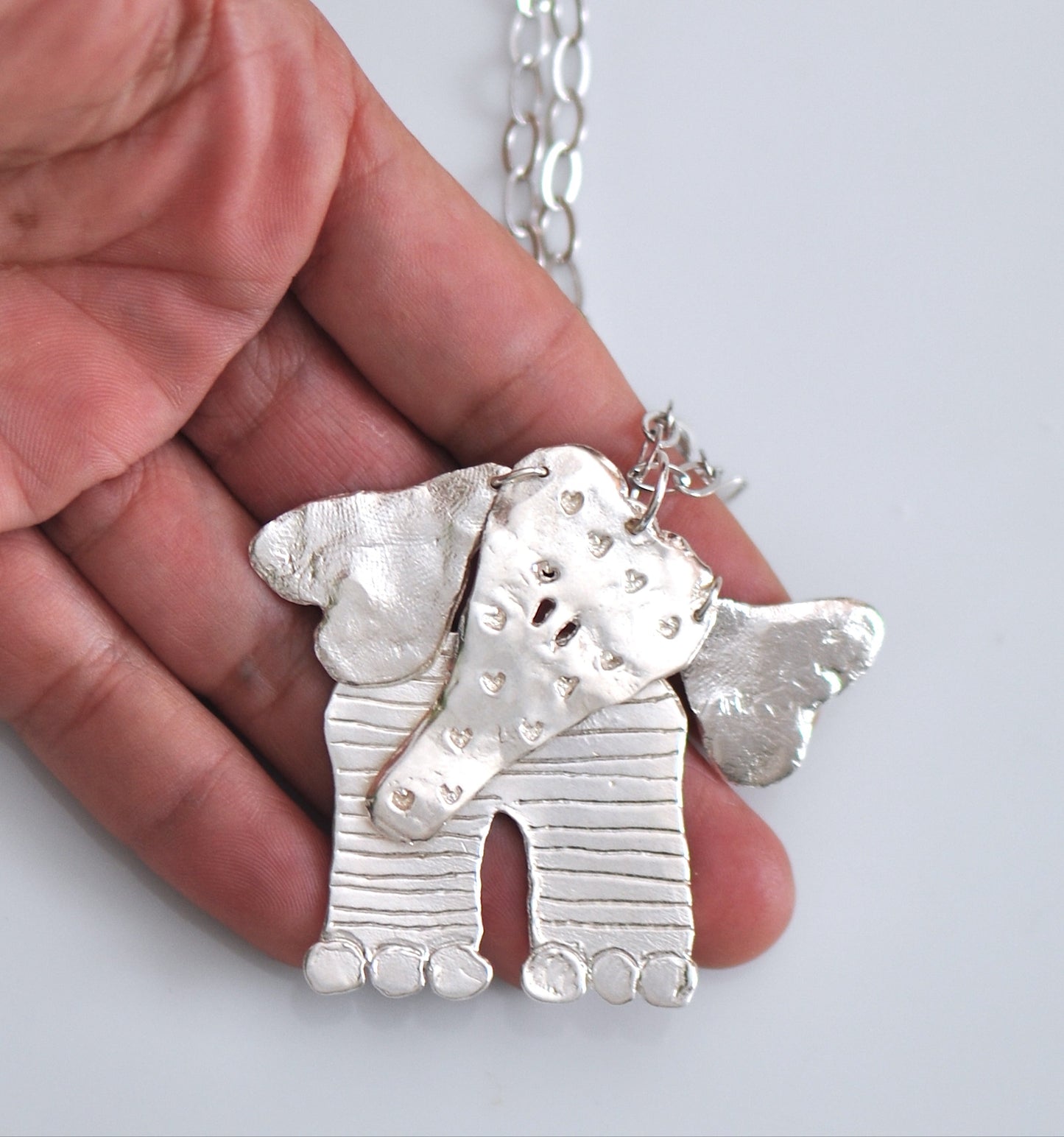 Handmade sterling silver articulated elephant necklace with textured sculptural design, whimsical animal jewelry