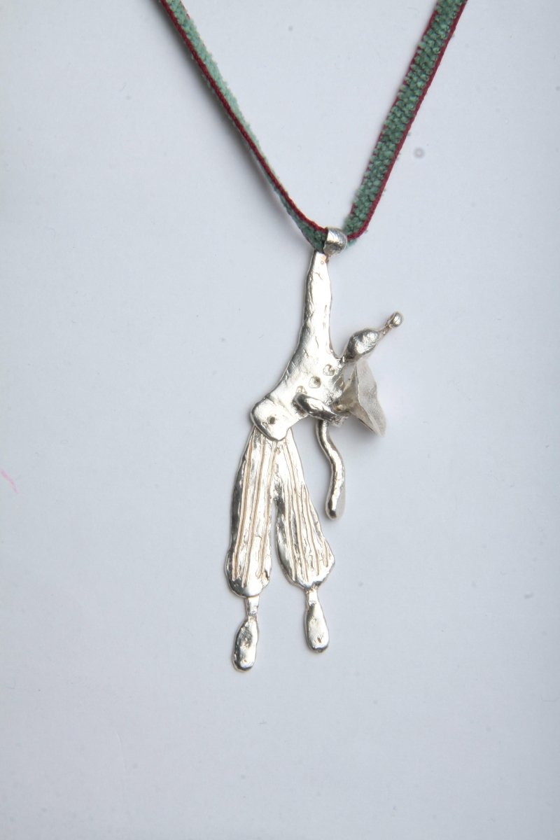 a silver necklace with a silver articulated clown