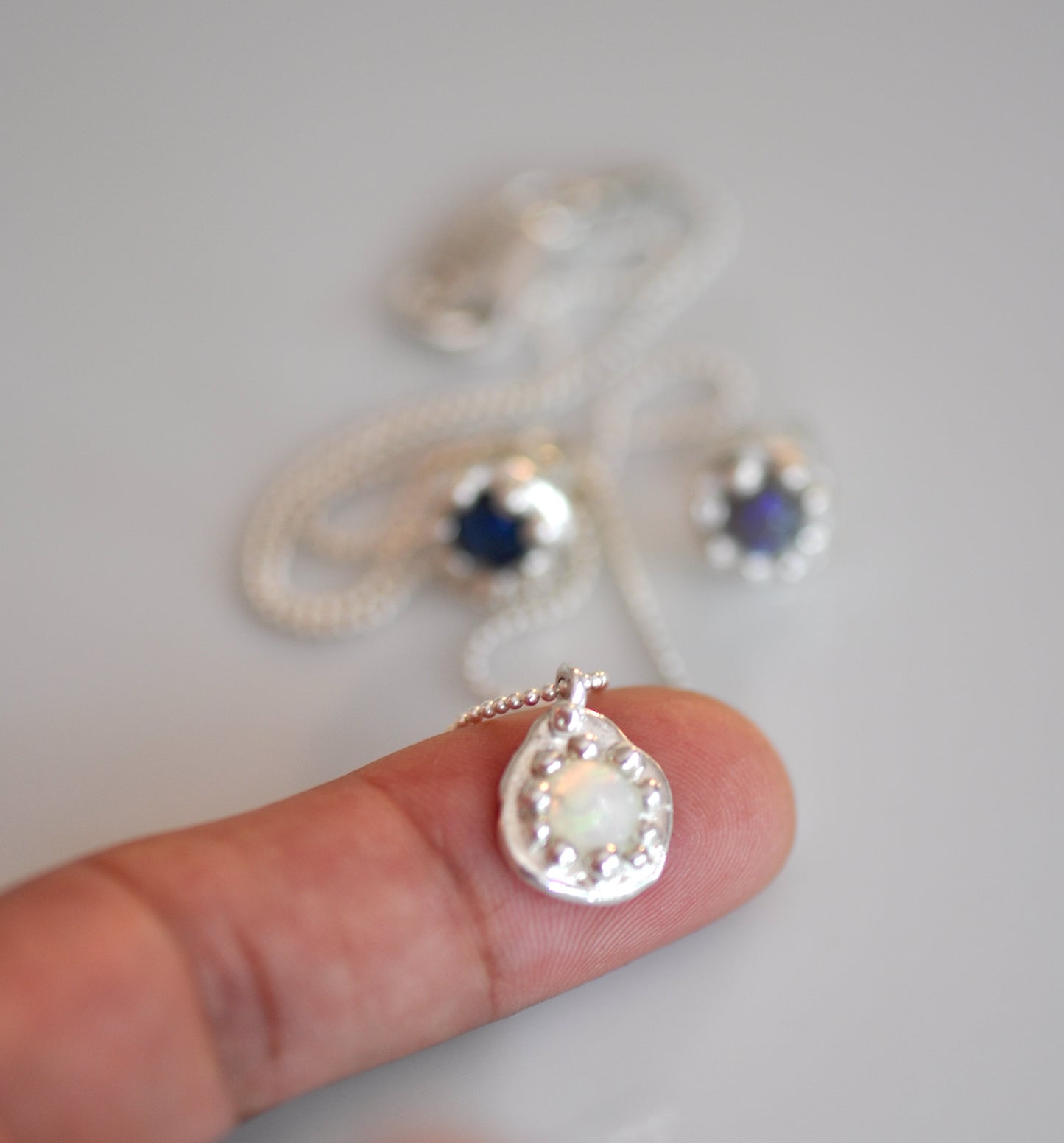 small fine silver charm with white opal