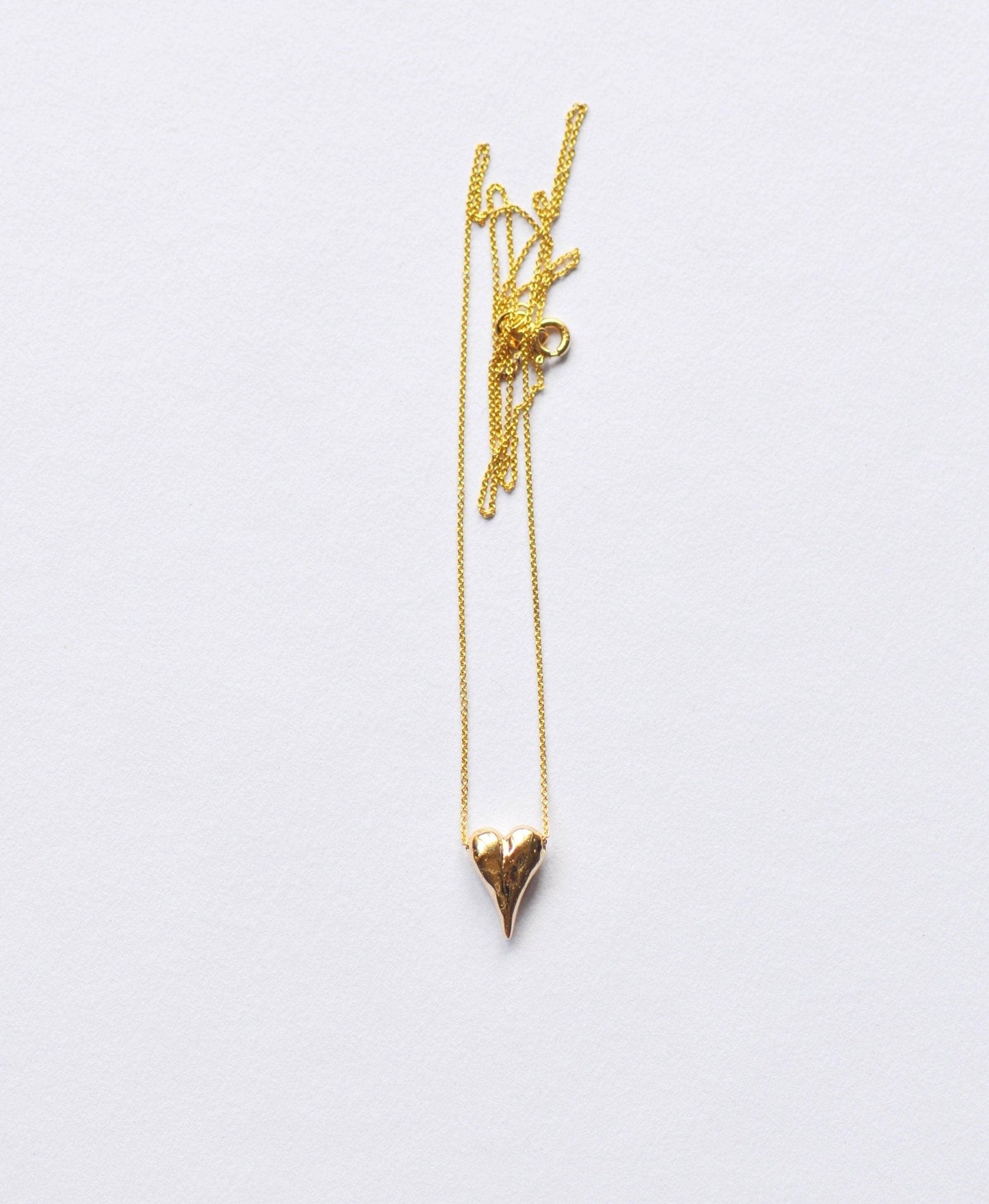 a gold necklace with a heart on a chain