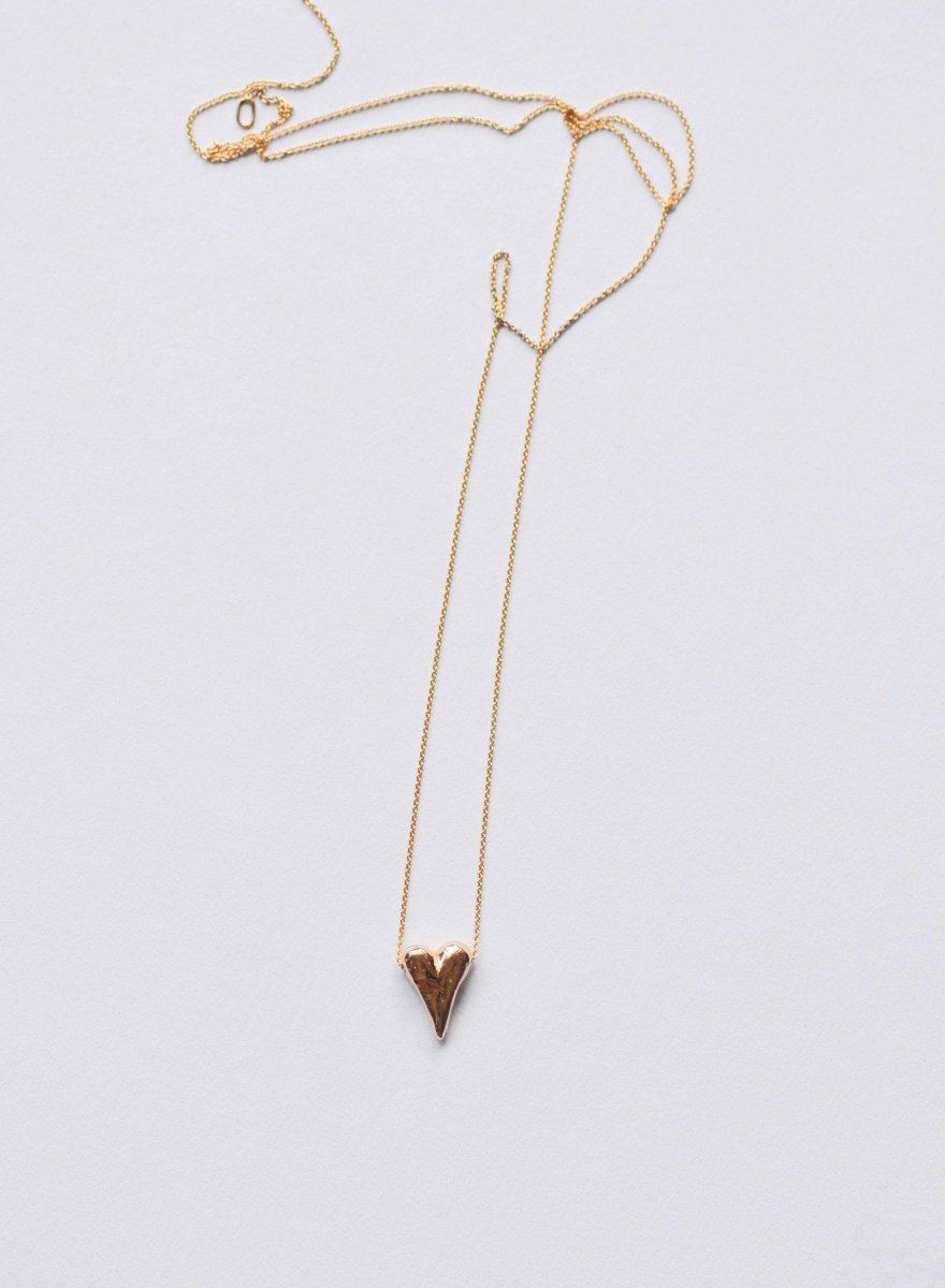 a gold necklace with a heart shaped pendant