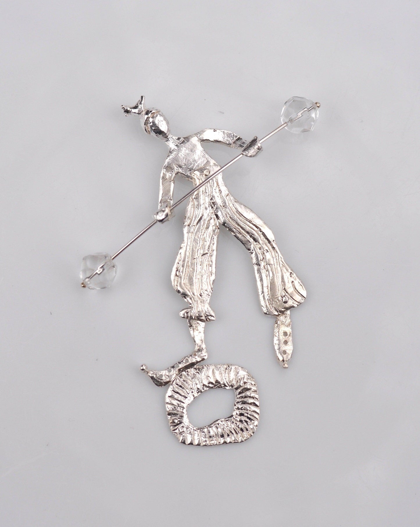 a silver brooch with a woman on it