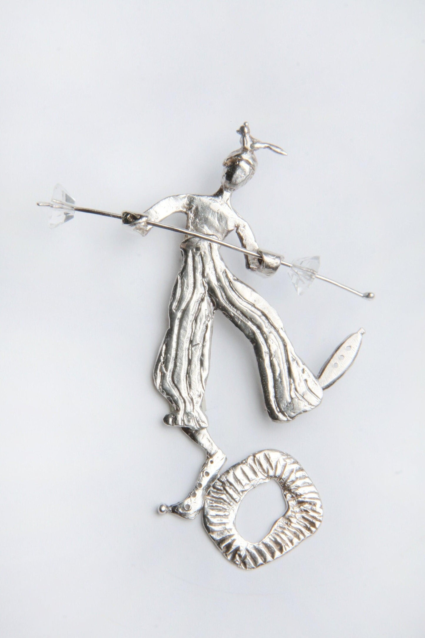 a silver figurine of a man holding a spear