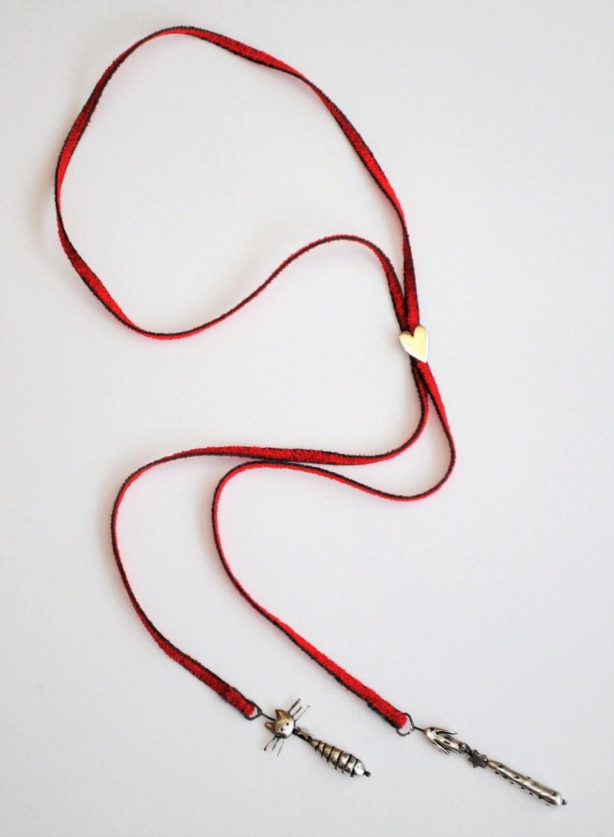 Handmade silver cat and dog charm lariat necklace on red cord with heart clasp, whimsical animal jewelry, made in Barcelona