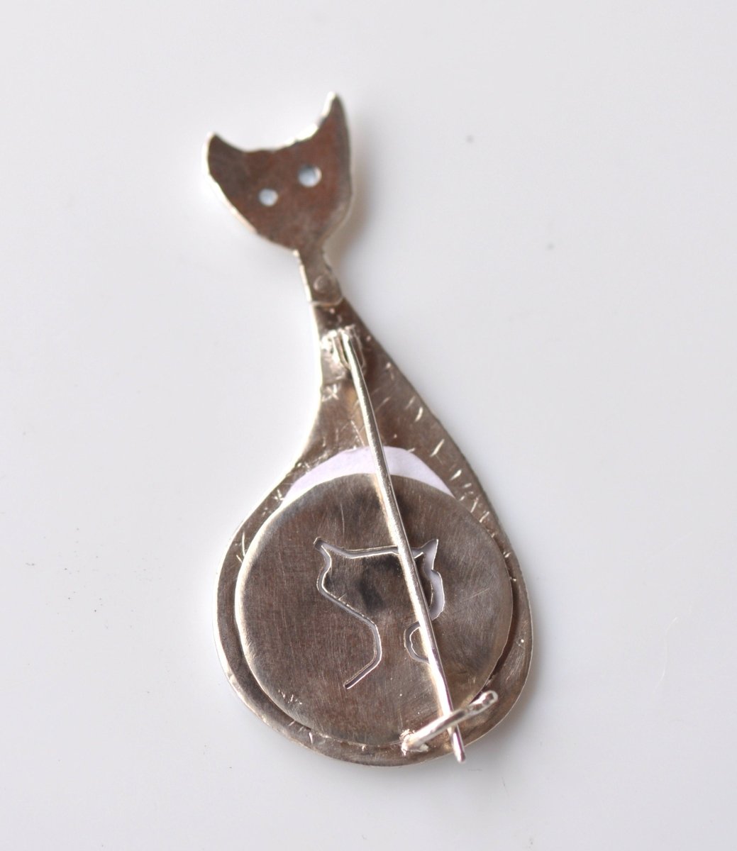 a spoon with a cat on it sitting on a table