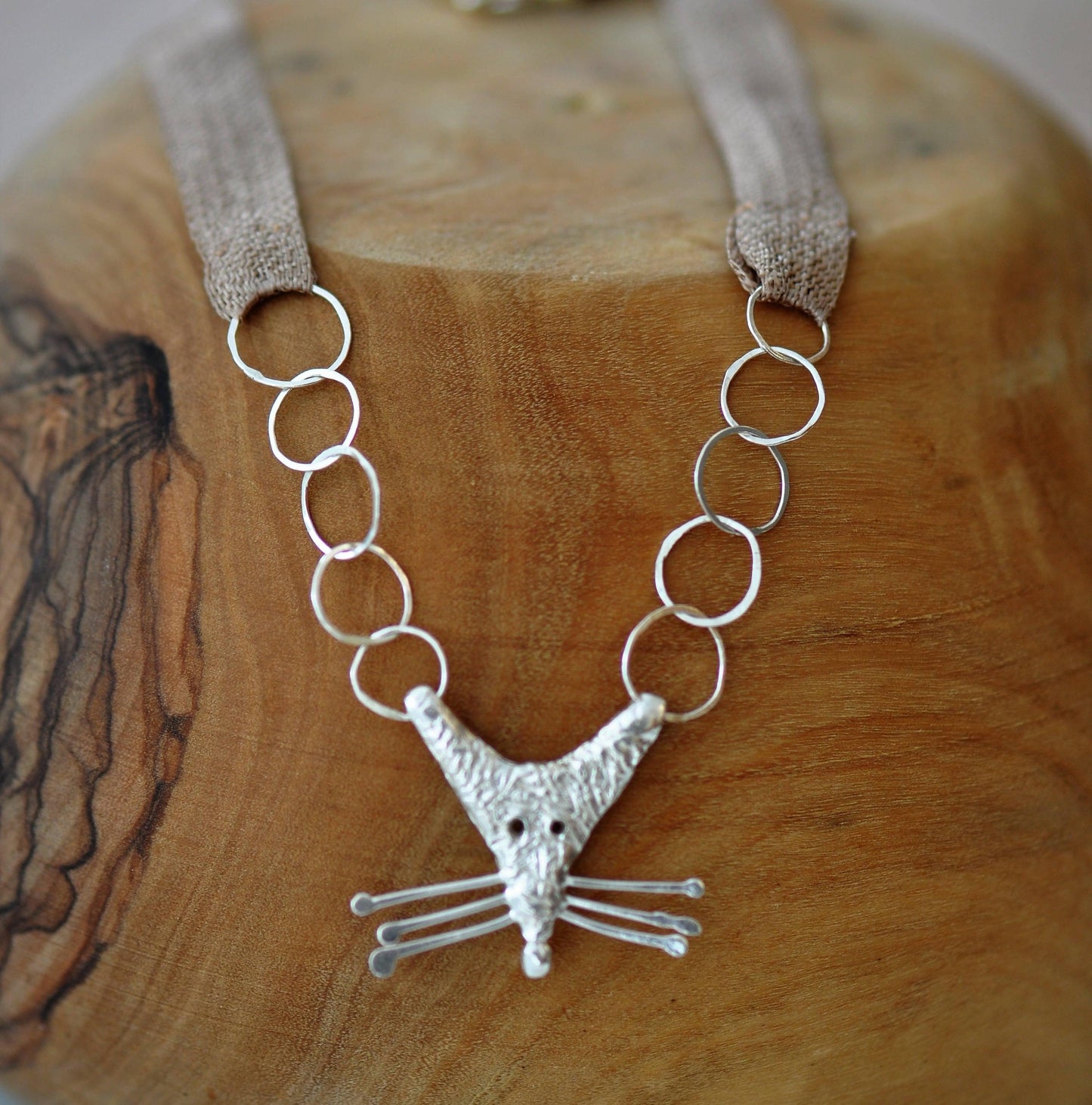 a silver necklace with a bird on it