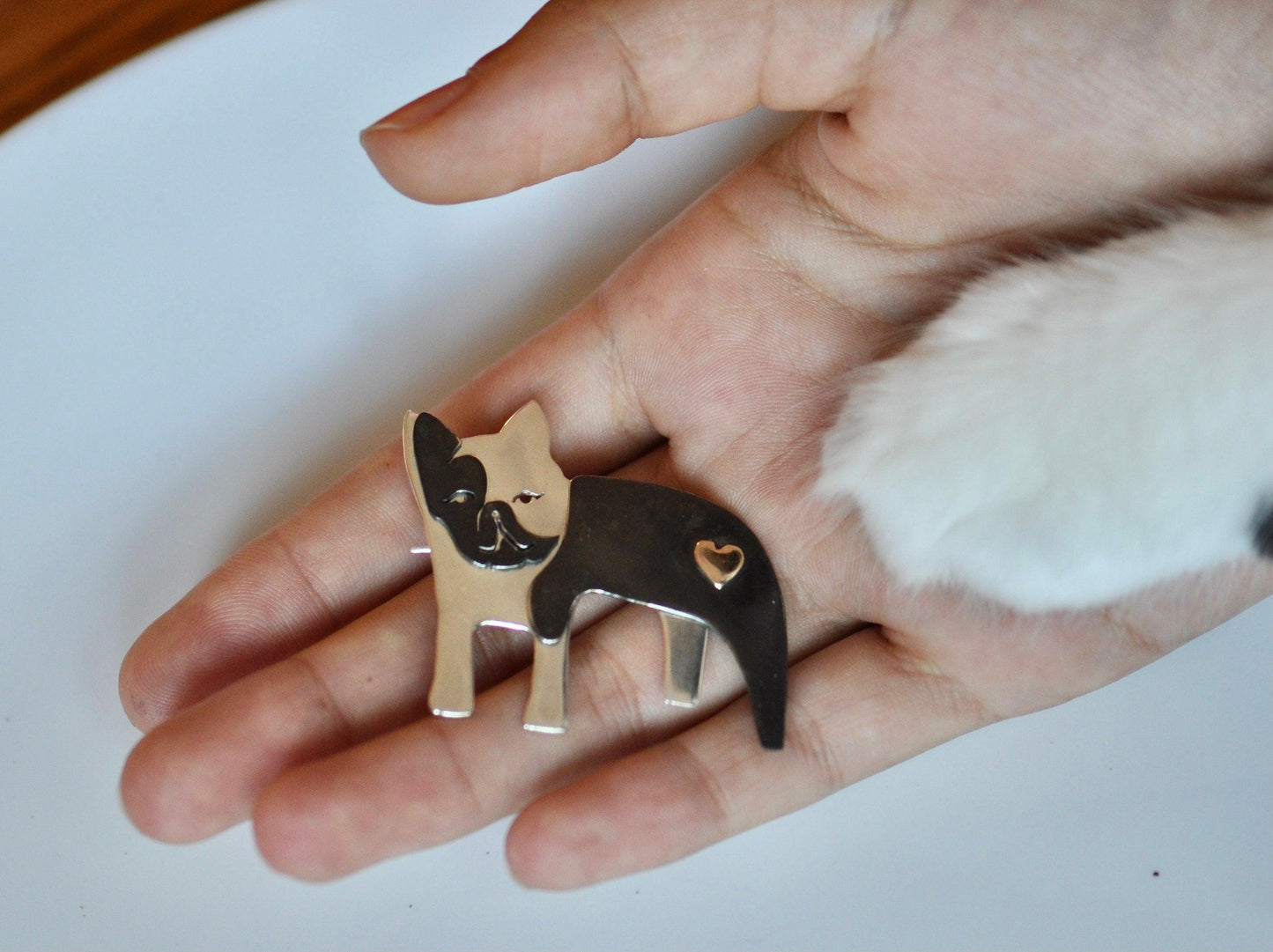 a person's hand holding a ring with a dog on it