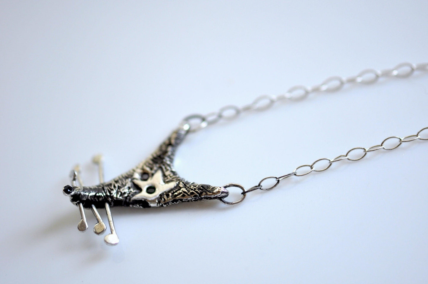 a silver necklace with a bird on it