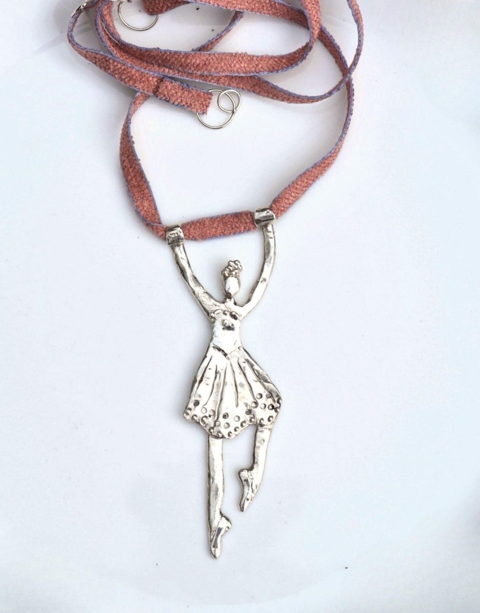 a necklace with a silver ballerina on it