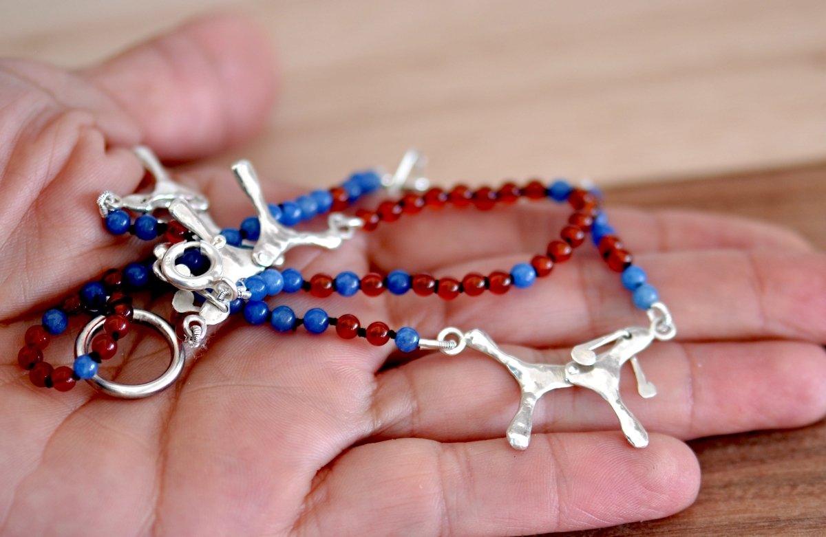 Handmade red and blue agate bead necklace with four articulated sterling silver dog charms, made in Barcelona