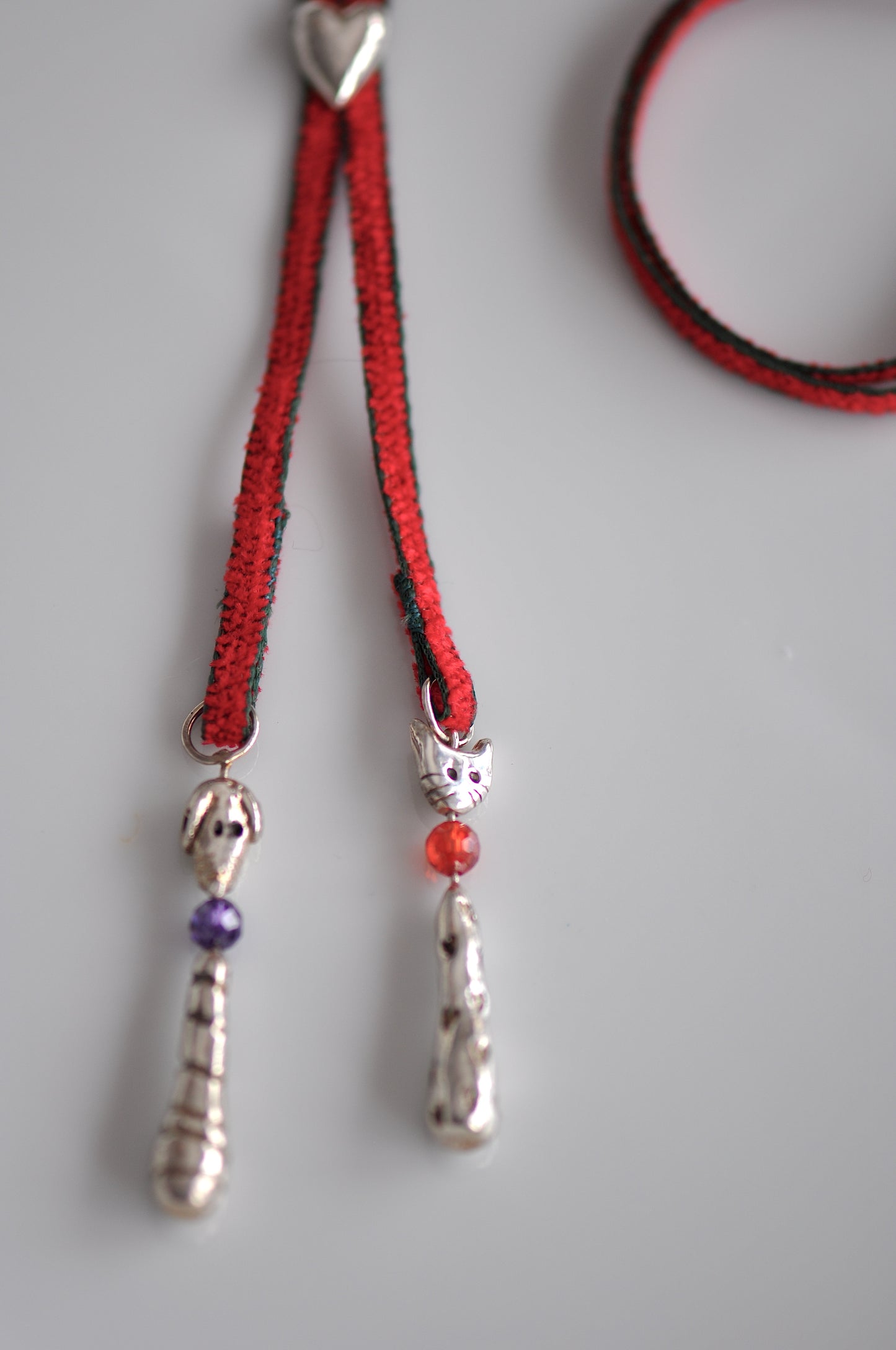 two silver charms dog and cat in a red lariat
