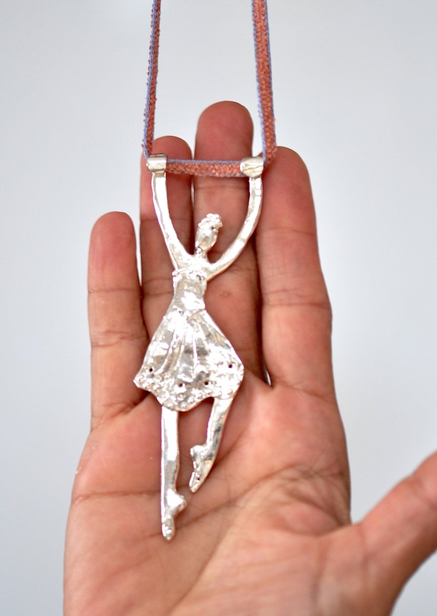 a person holding a piece of jewelry in their hand