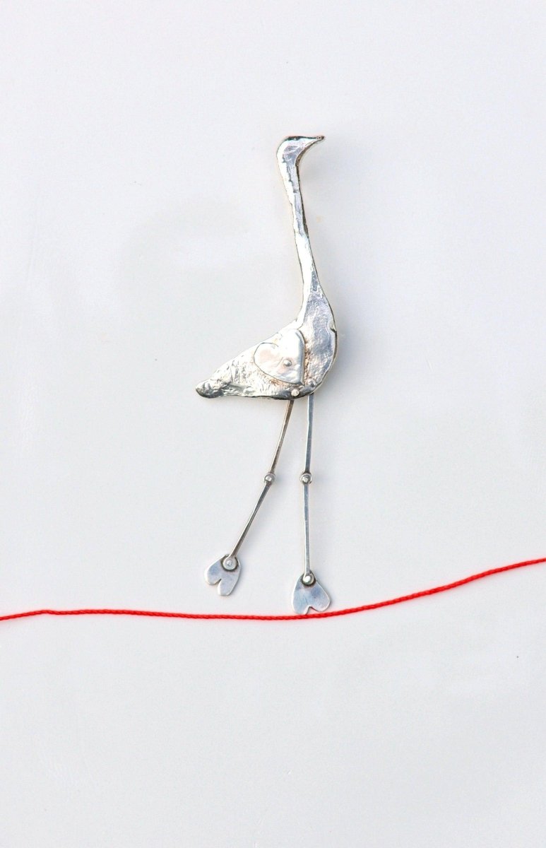 a bird made out of metal and wire on a white surface