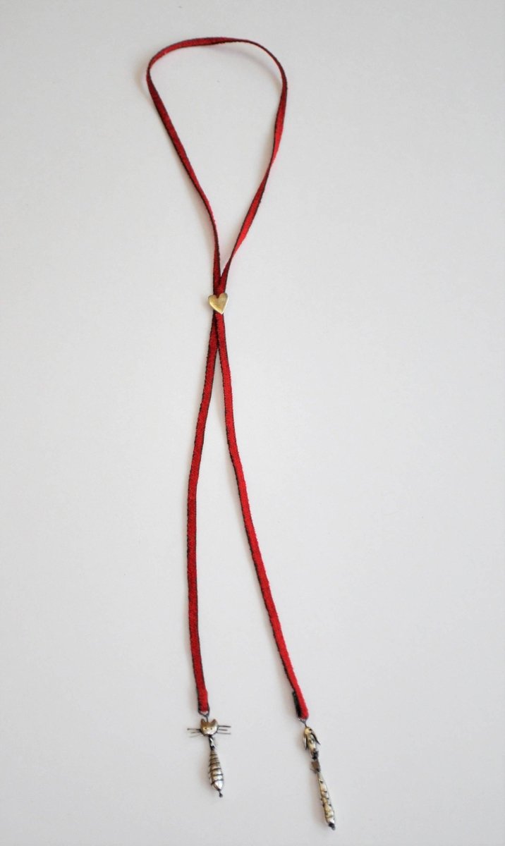 Handmade silver cat and dog charm lariat necklace on red cord with heart clasp, whimsical animal jewelry, made in Barcelona