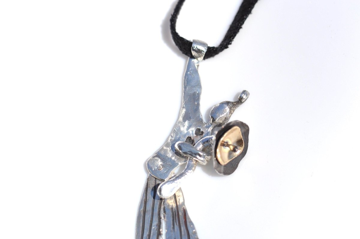 a silver and gold necklace with a articulated clown holding a big flower
