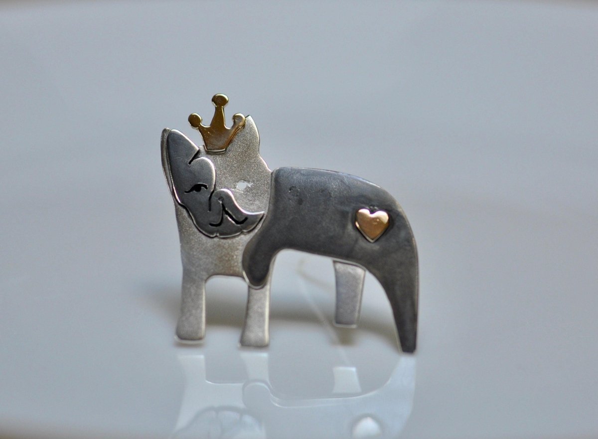 a silver and gold ring with a cat wearing a crown