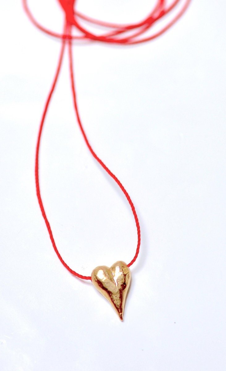 a red string with a gold heart on it