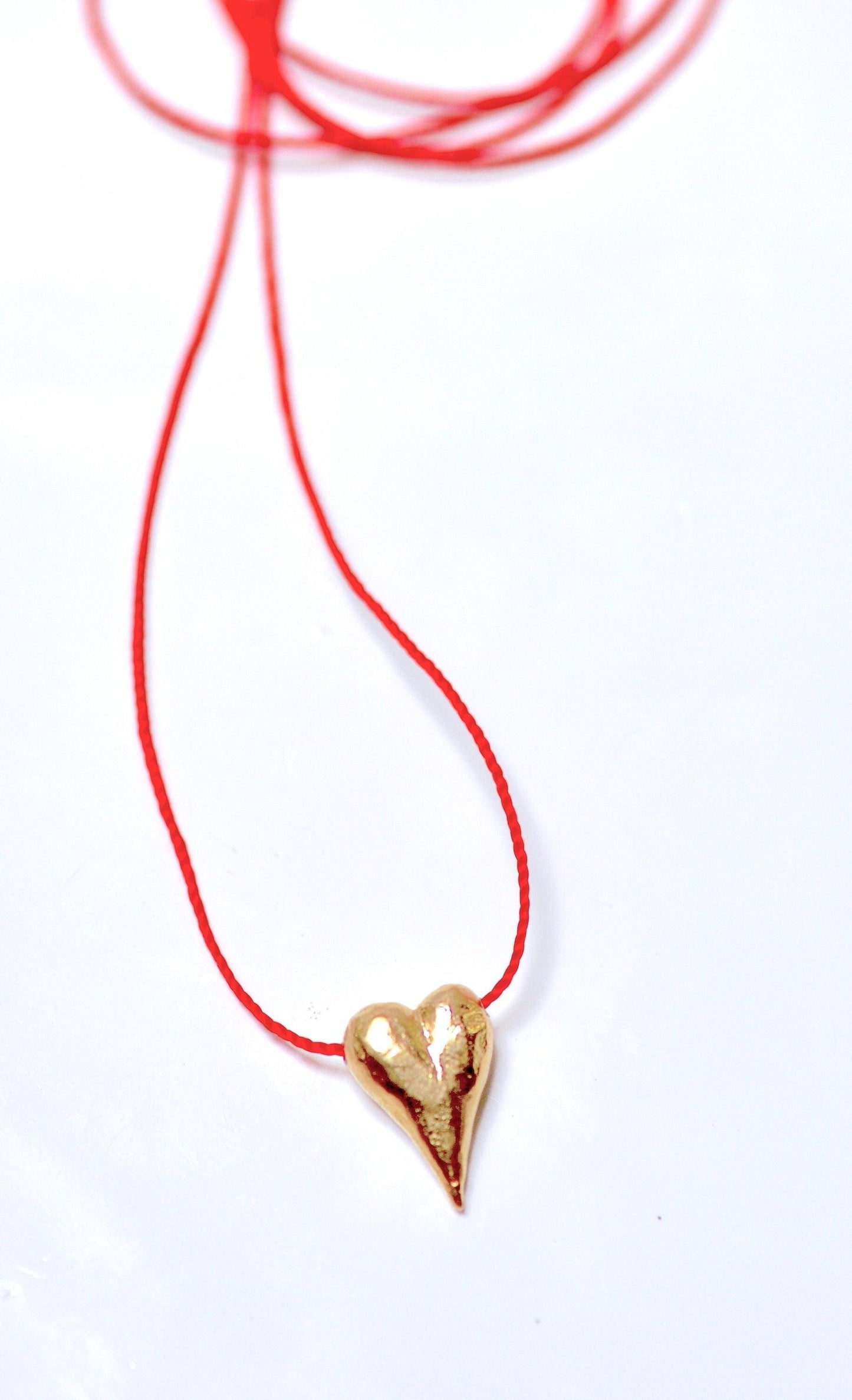 a red string with a gold heart on it