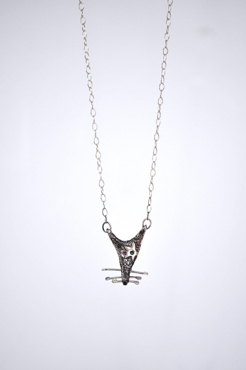 a silver necklace with a black and white cat on it