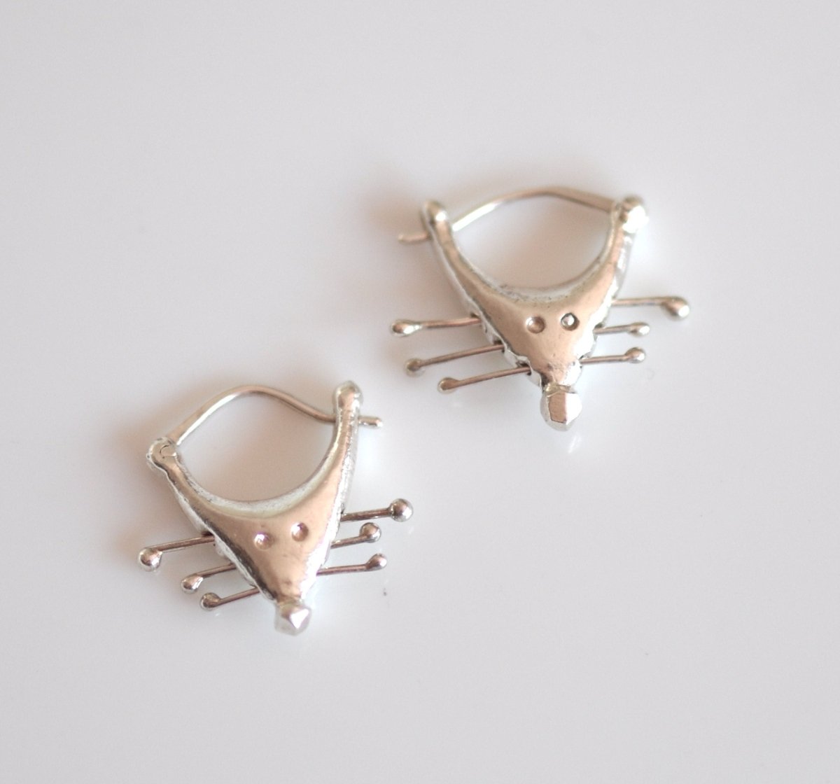 a pair of silver rat earrings 