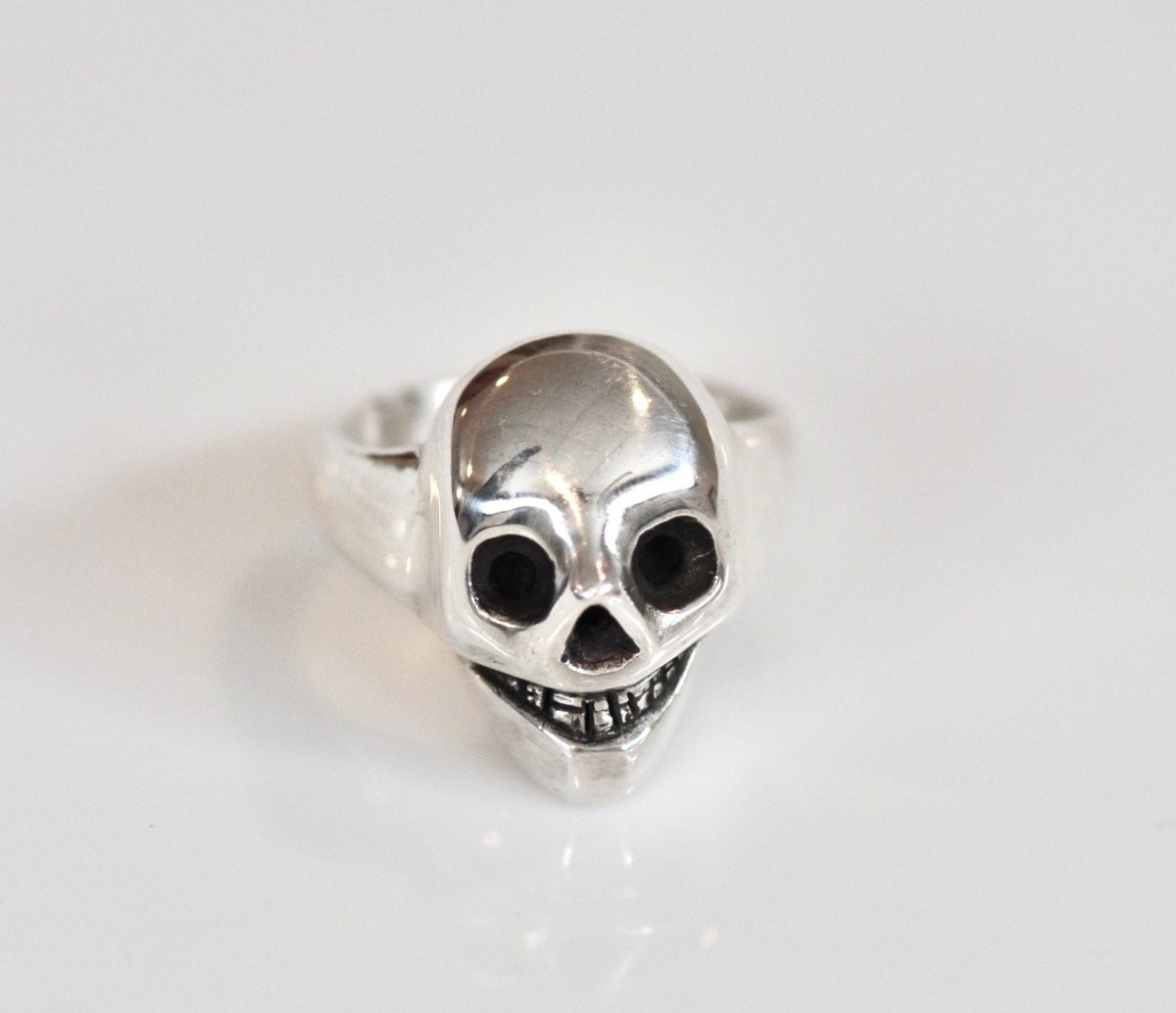 Handmade sterling silver grinning skull ring with polished finish and dark eye sockets, statement ring, made in Barcelona