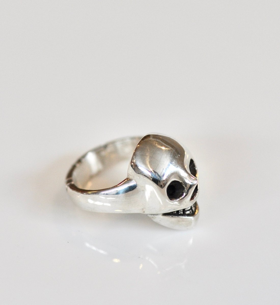 Handmade sterling silver grinning skull ring with polished finish and dark eye sockets, statement ring, made in Barcelona