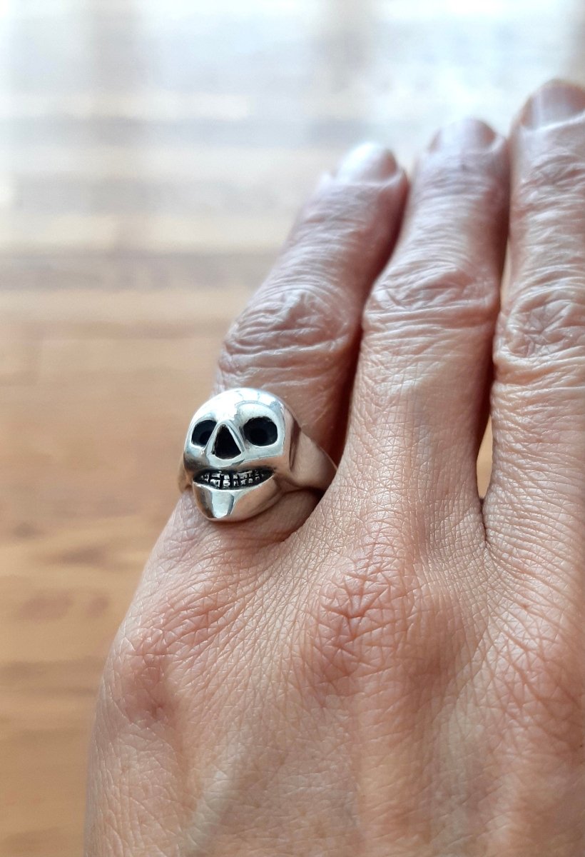 Handmade sterling silver grinning skull ring with polished finish and dark eye sockets, statement ring, made in Barcelona